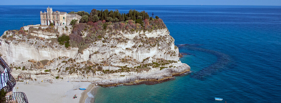 Best Calabria Beaches – The Most Alluring Stretches of Sand. Santa Maria dell'Isola punctuates the small 'island' off Tropea, Vibo Valentia, Calabria, Italy. Copyright © 2022 Terence Carter / Grantourismo. All Rights Reserved.